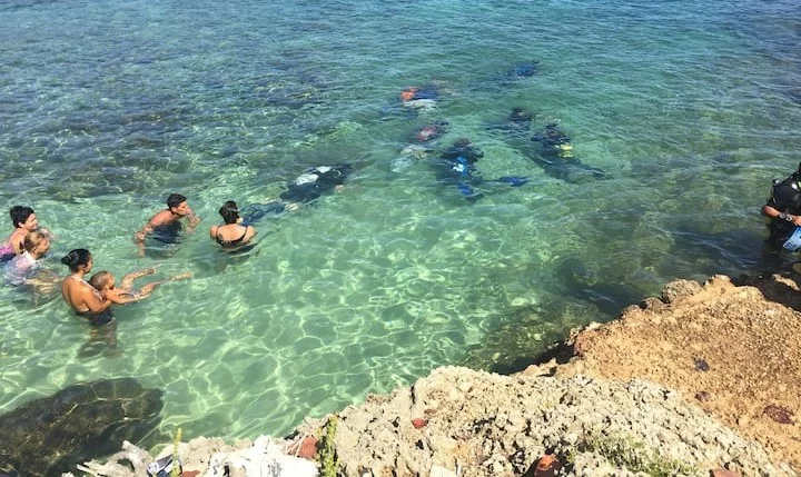 Family snorkeling together above coral reef in Varadero, Cuba