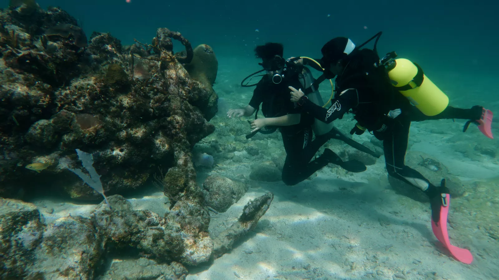Discover scuba diving in Varadero Cuba with instructor guiding beginner near coral reef and anchor covered in coral