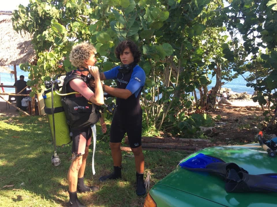 Instructor Checking A beginner before getting first scuba diving of discover program