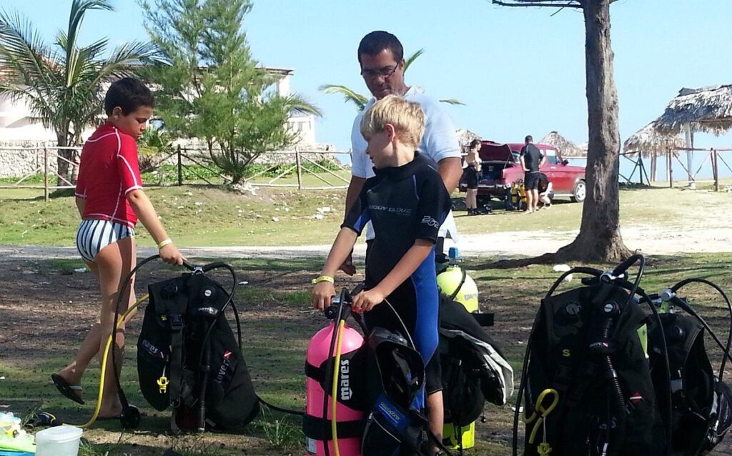 Scuba instructor guiding children during a family diving experience in Varadero