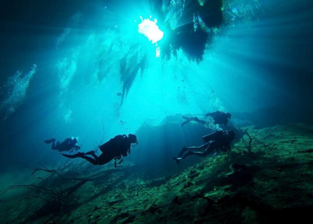 Scuba diver swimming through sunlight rays underwater in Varadero Cuba