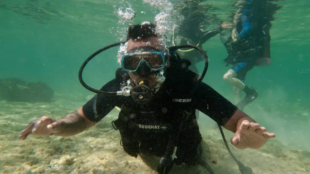 Beginner scuba diver breathing through a regulator underwater